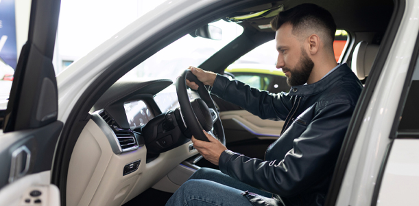 Man inspecting new car at dealership